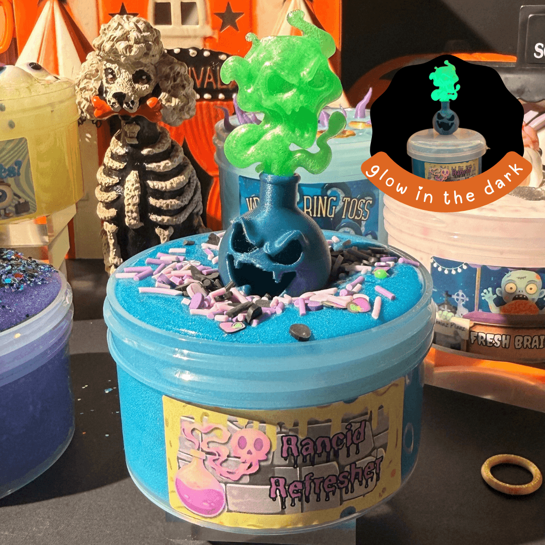 Blue Rancid Refresher slime in a jar topped with purple sprinkles and a glowing green potion bottle charm