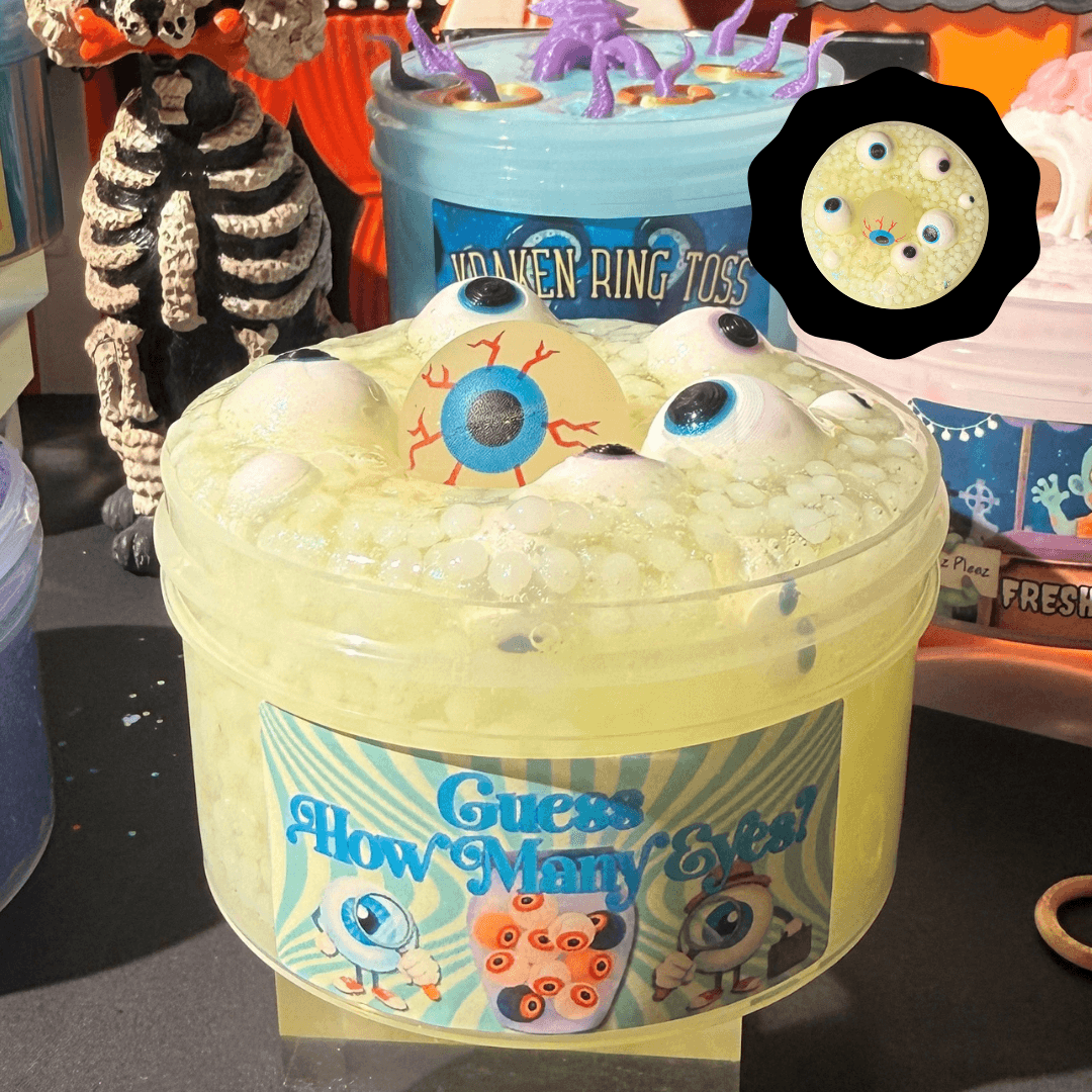 Clear green slush bead Guess How Many Eyes slime in a jar topped with 3D-printed eyeball charms and a glow-in-the-dark eyeball topper.