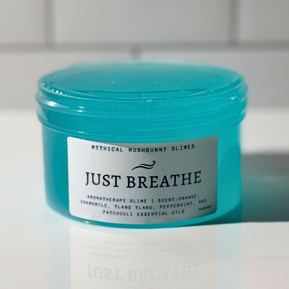 Just Breathe aromatherapy clear slime in a transparent jar featuring a custom label with essential oils scent details.