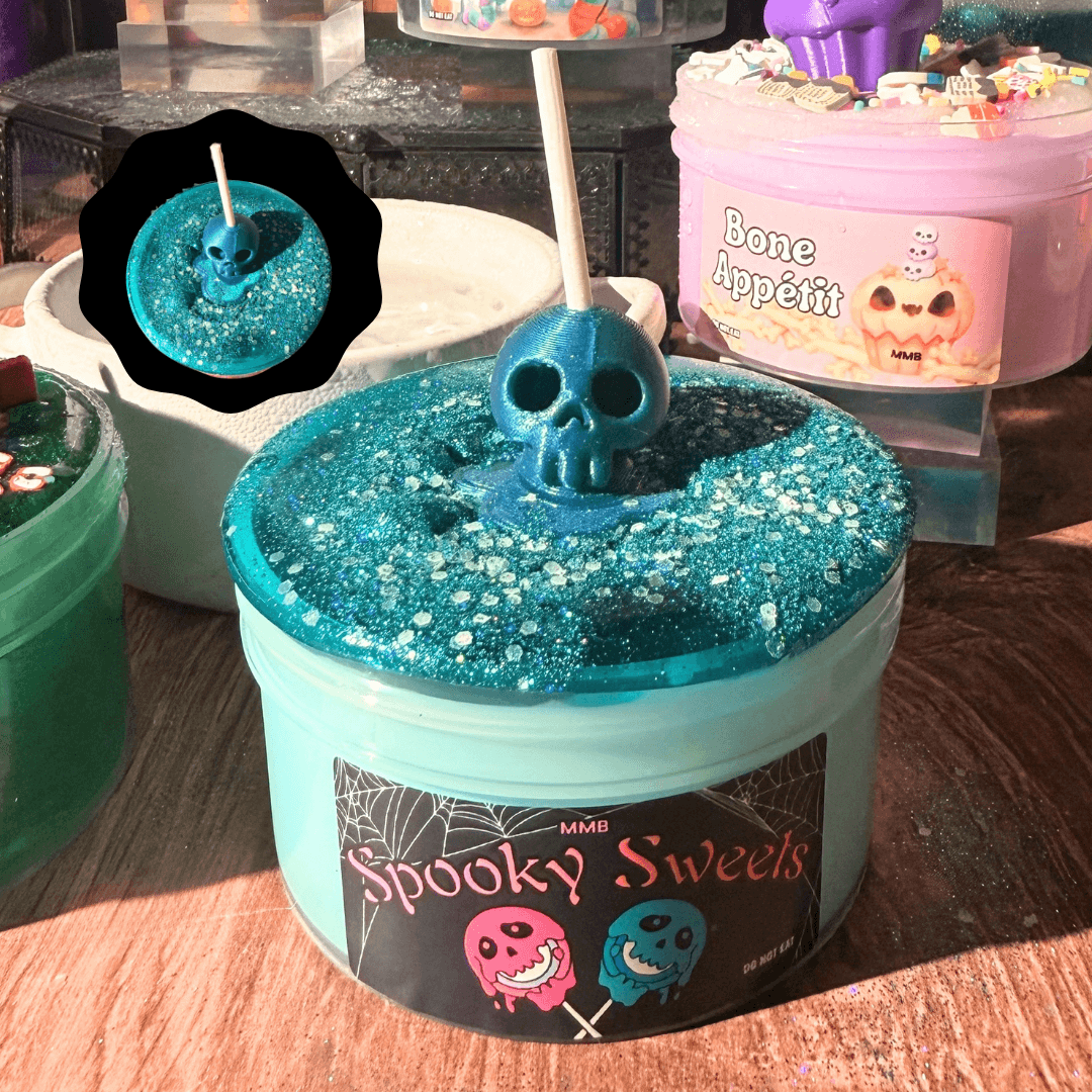 spooky sweets halloween slime jar with glittery teal wood glue base, topped with teal clear slime and blue skull lollipop figure