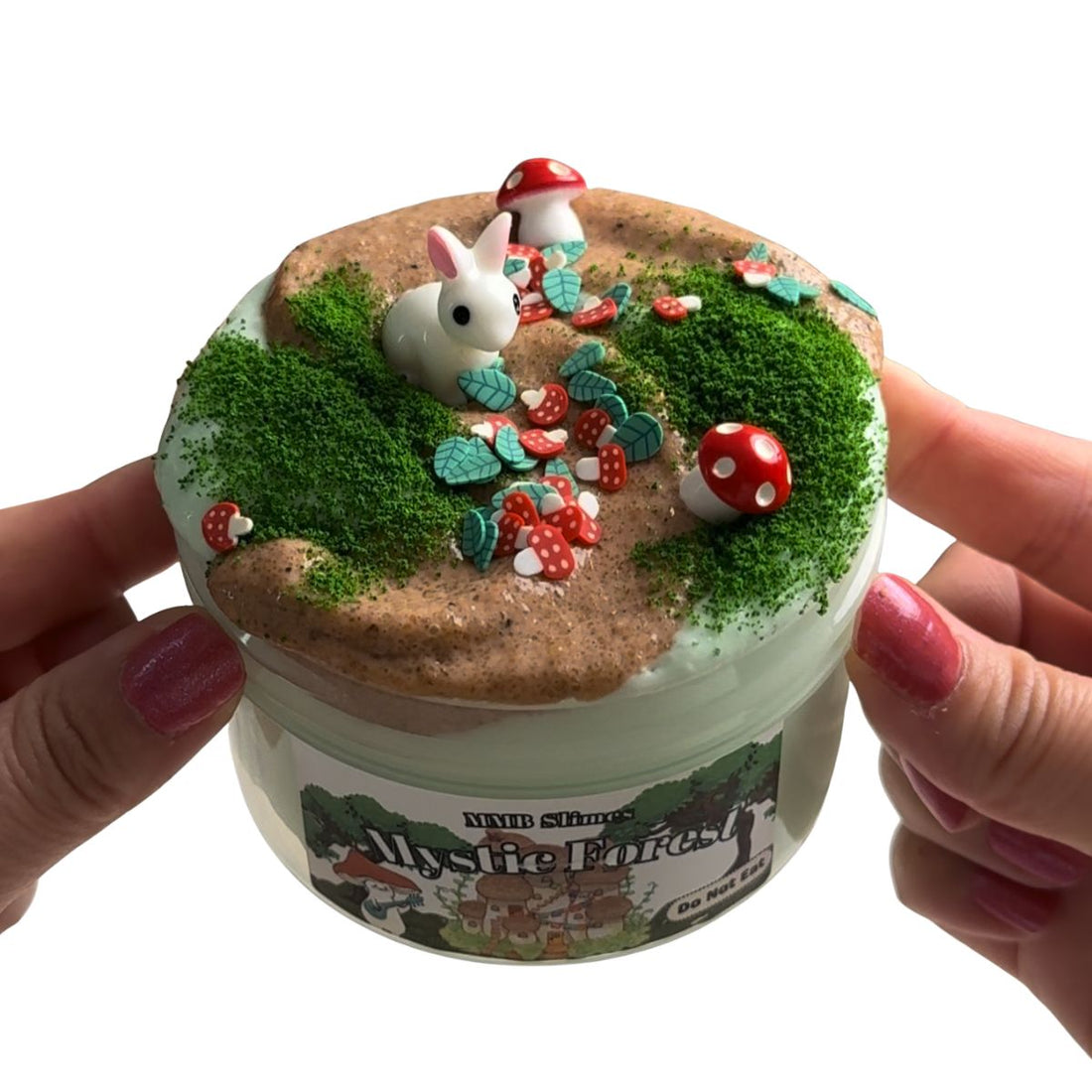 Mystic Forest slime with sand topper, green moss fake snow, red mushroom charms, green leaf fimo, and a white rabbit charm.