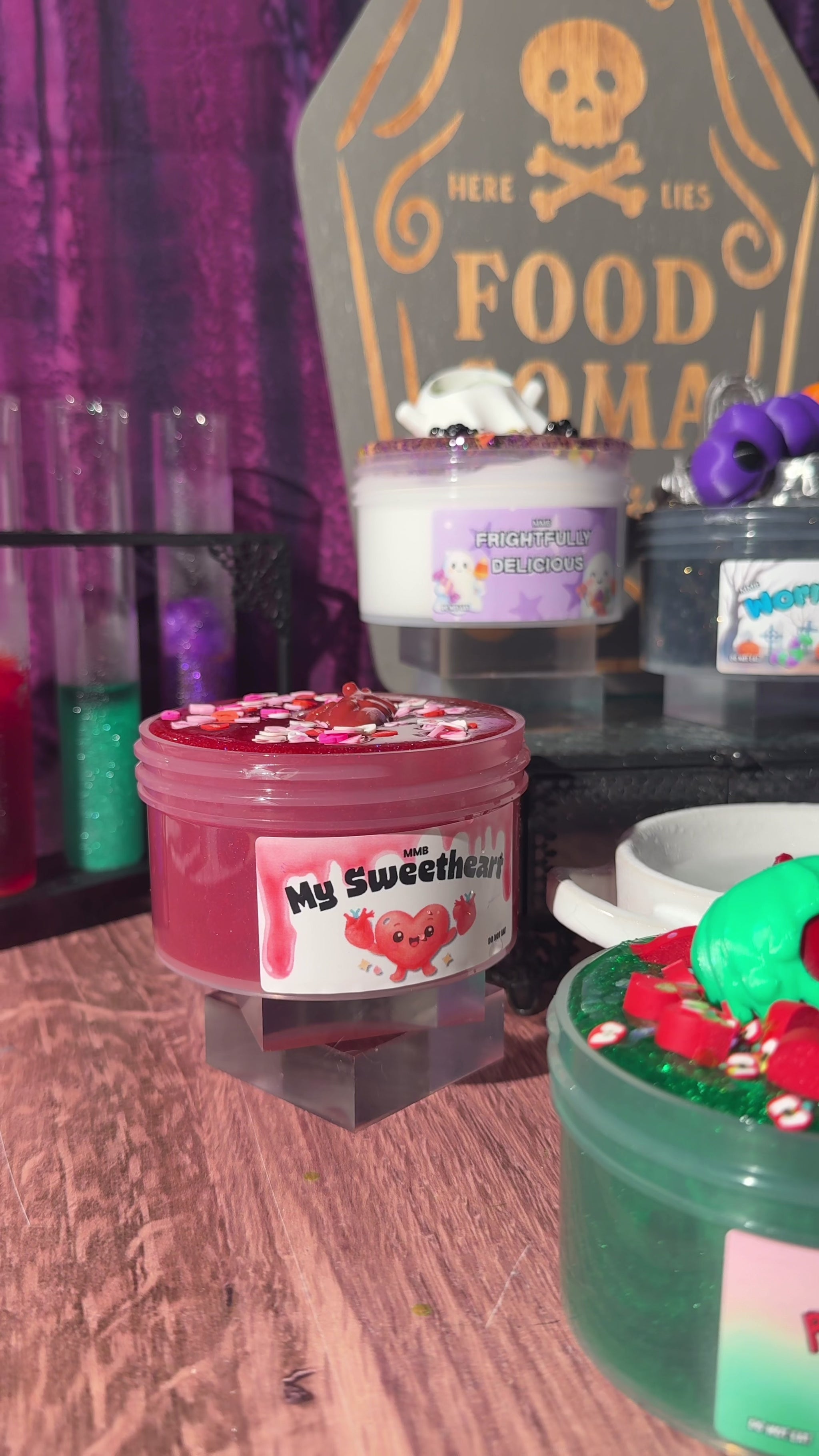 Video showing a close-up preview of Halloween-themed slimes from the Midnight Snacks collection, featuring My Sweetheart, Frightfully Delicious, and Worm Food with a graveyard tombstone background.